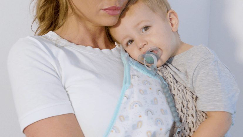 Parent holding toddler close using Cool Cuddle