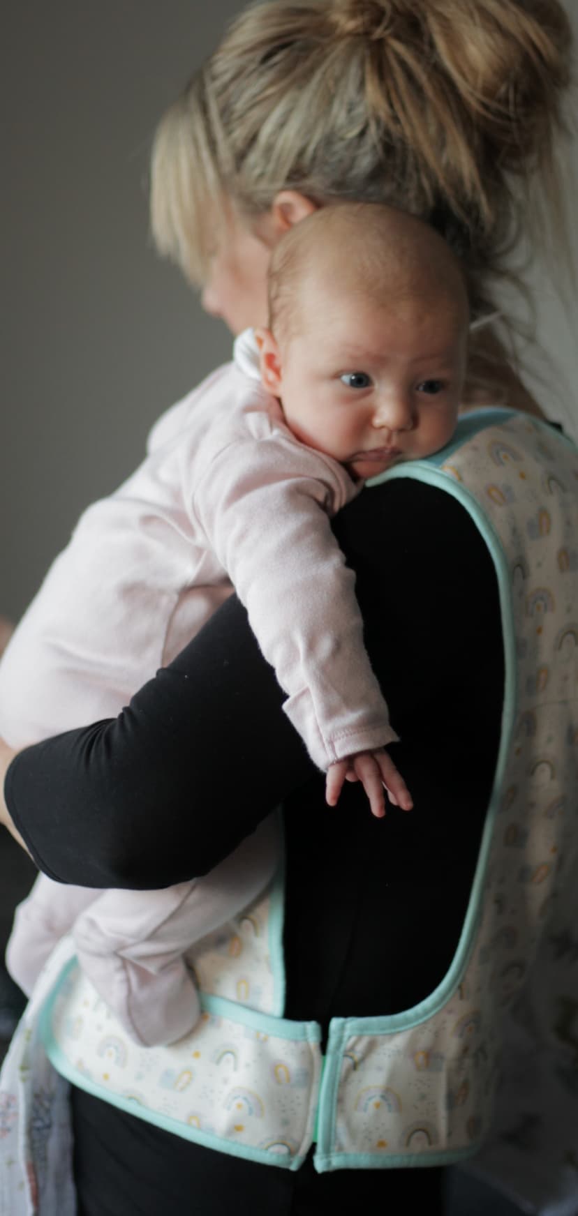 Parent holding baby while wearing the Cool Cuddle sling