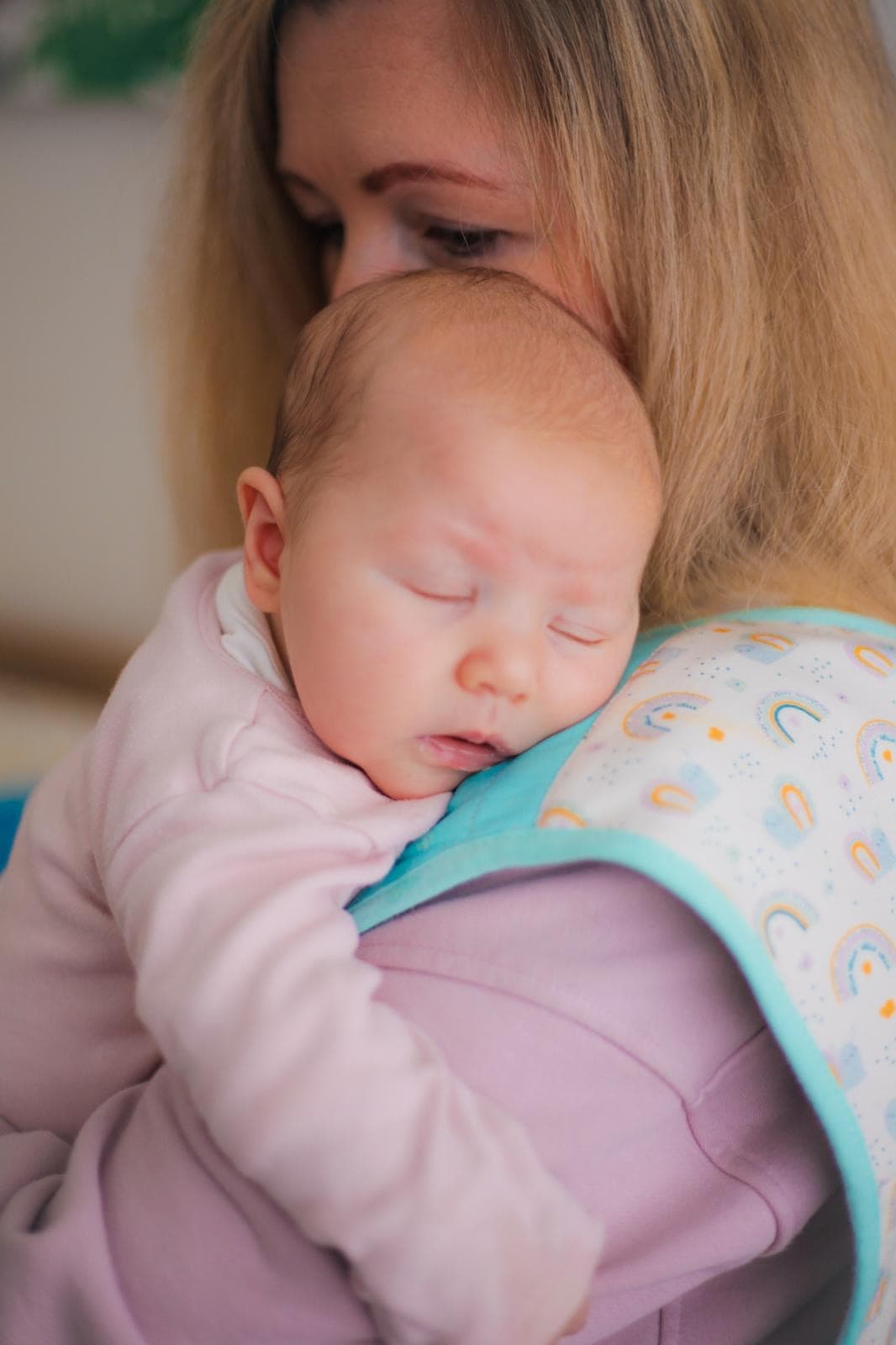 Parent cradling a sleeping baby against the Cool Cuddle cooling vest